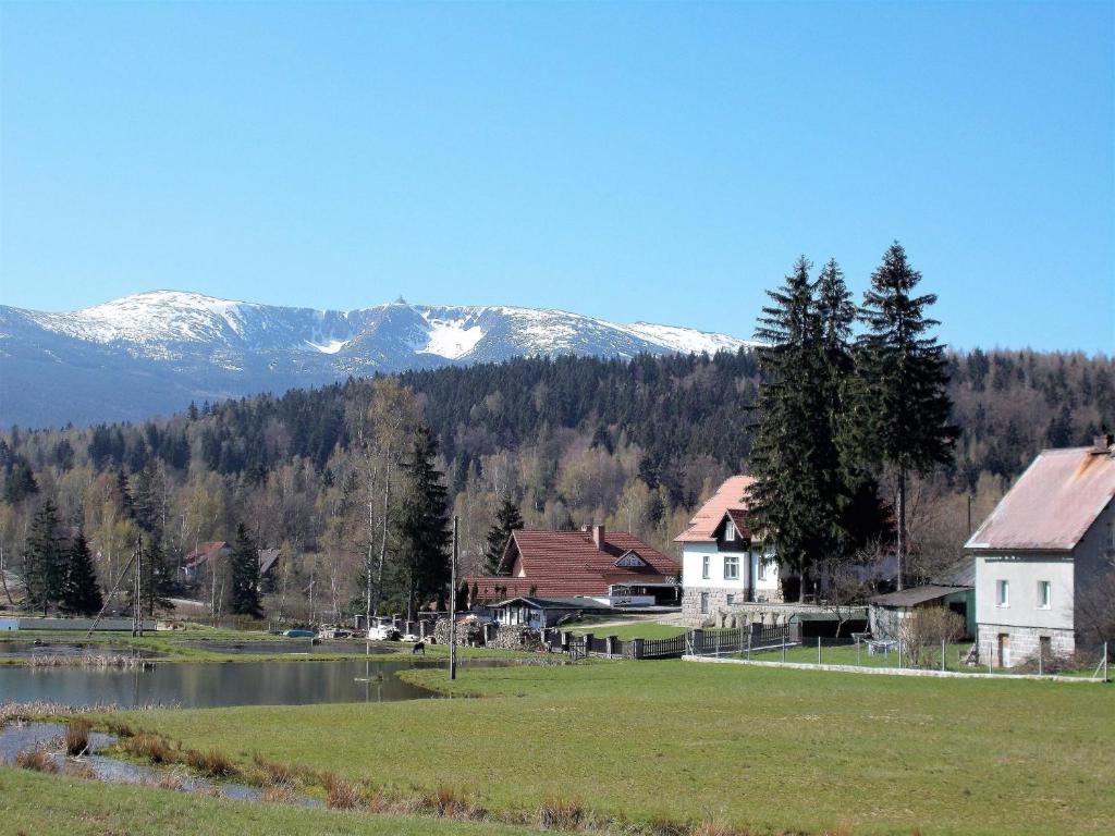 a village with a lake and mountains in the background at Pod Śnieżnymi Kotłami in Piechowice