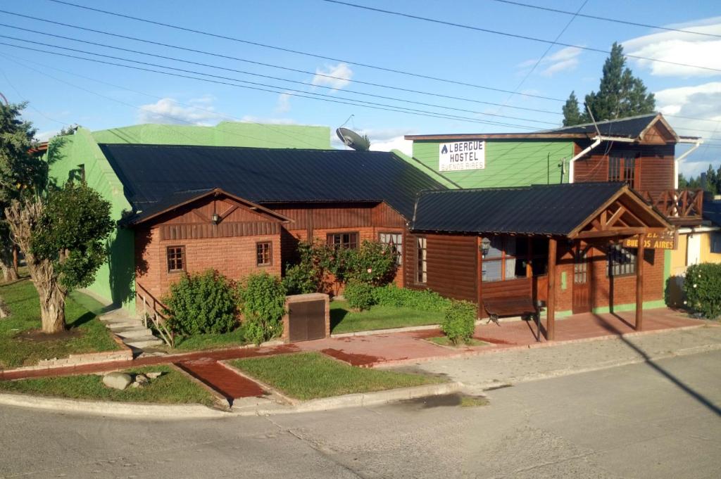 a house with a black roof and a green at Hostel Buenos Aires in El Calafate