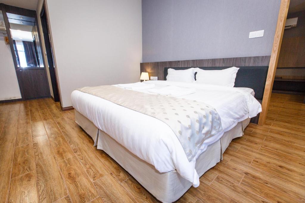 Postel nebo postele na pokoji v ubytování Lintas Platinum Hotel