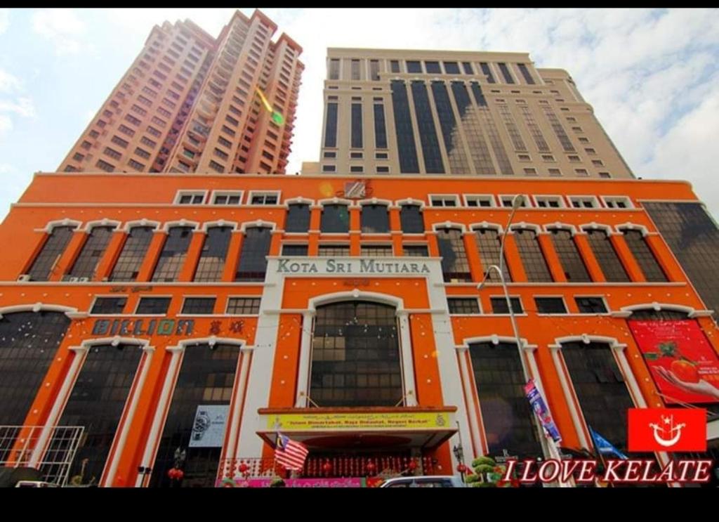 哥打巴魯的住宿－# Free Netflix CMK KONDOMINIUM KOTA SRI MUTIARA，一座橙色的建筑,有两座高大的建筑