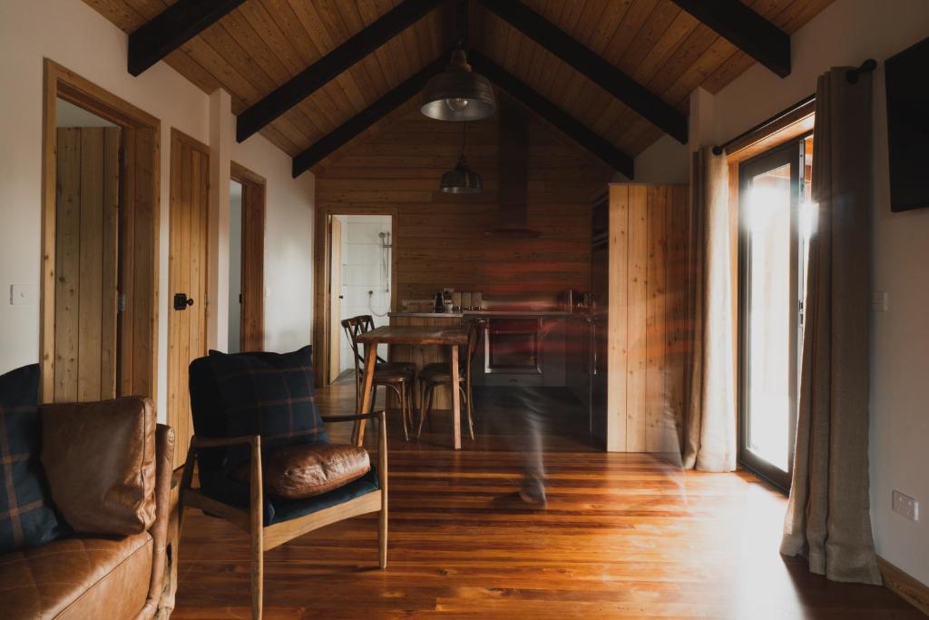 a living room with wooden floors and a table and chairs at Alpine Lodges in Lake Tekapo