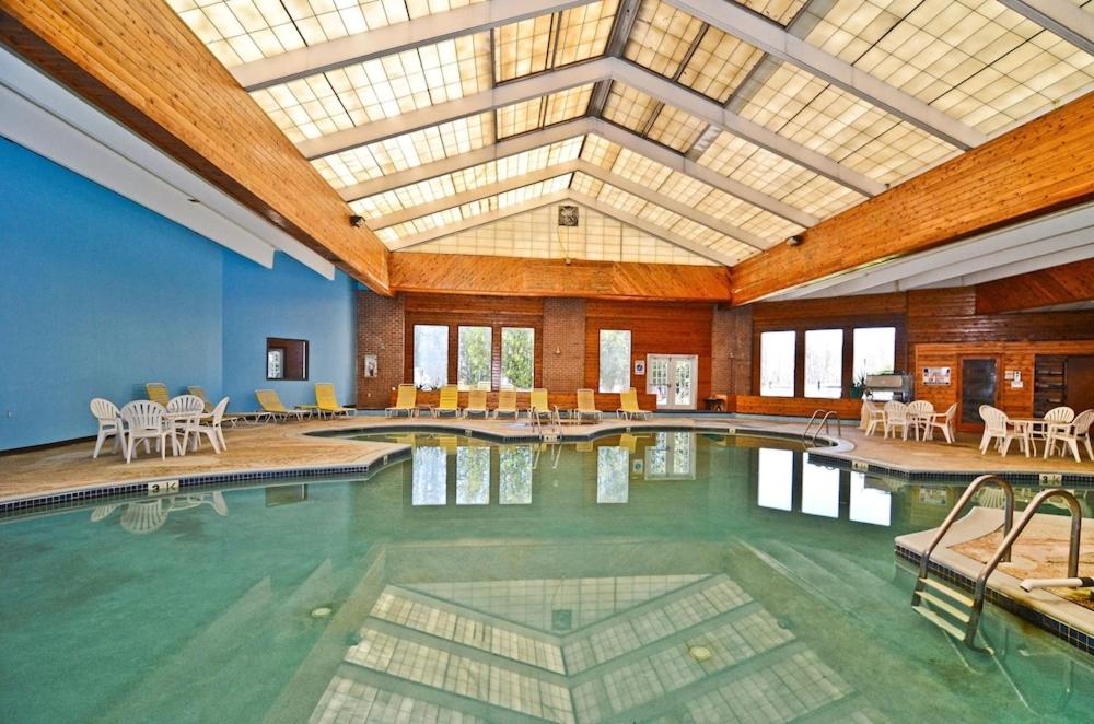 une grande piscine avec des tables et des chaises dans un bâtiment dans l'établissement Pocono Resort & Conference Center - Pocono Mountains, à Lake Harmony