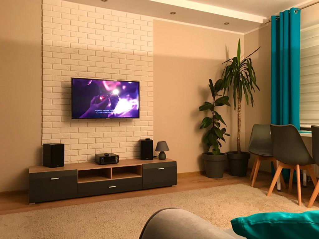 a living room with a tv on a brick wall at Apartament Brzoza Bydgoska in Brzoza