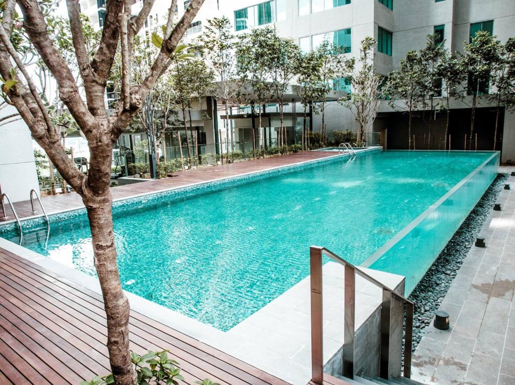 a swimming pool in a building with a tree at Amethyst KLCC in Kuala Lumpur