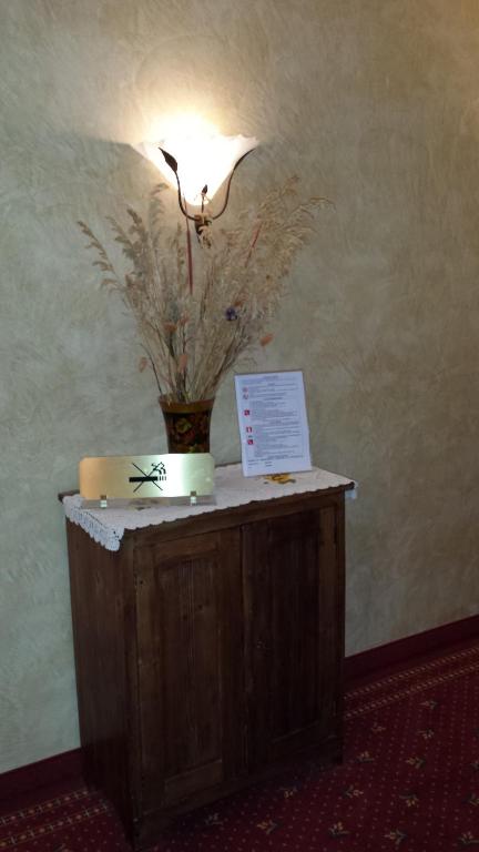 stół z lampą i wazonem kwiatów w obiekcie Hotel Pesek w mieście San Dorligo della Valle