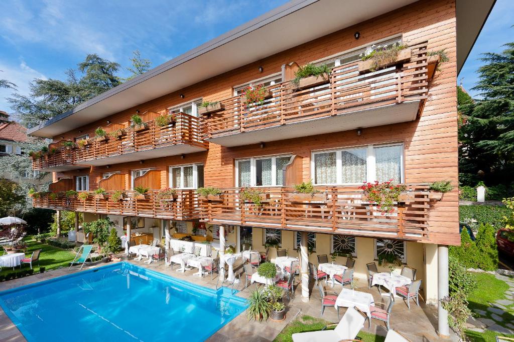 a hotel with a swimming pool and a balcony at Hotel Aster in Merano