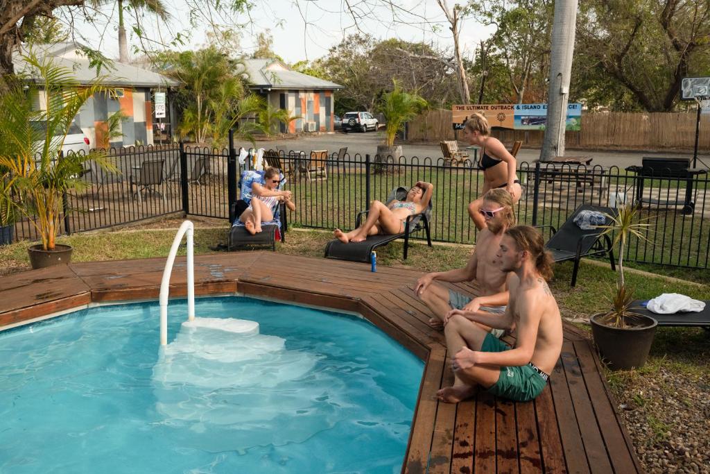 a group of people sitting around a swimming pool at Rockhampton Backpackers YHA in Rockhampton