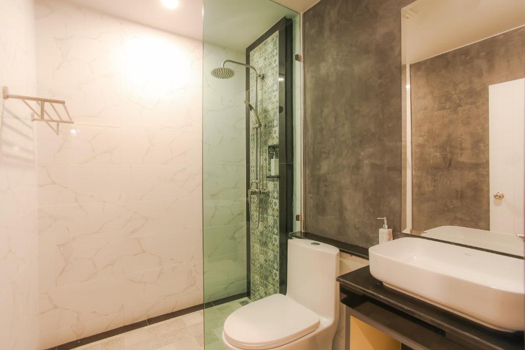 a bathroom with a sink and a toilet and a shower at The Mantra Hotel Kata Noi in Kata Beach
