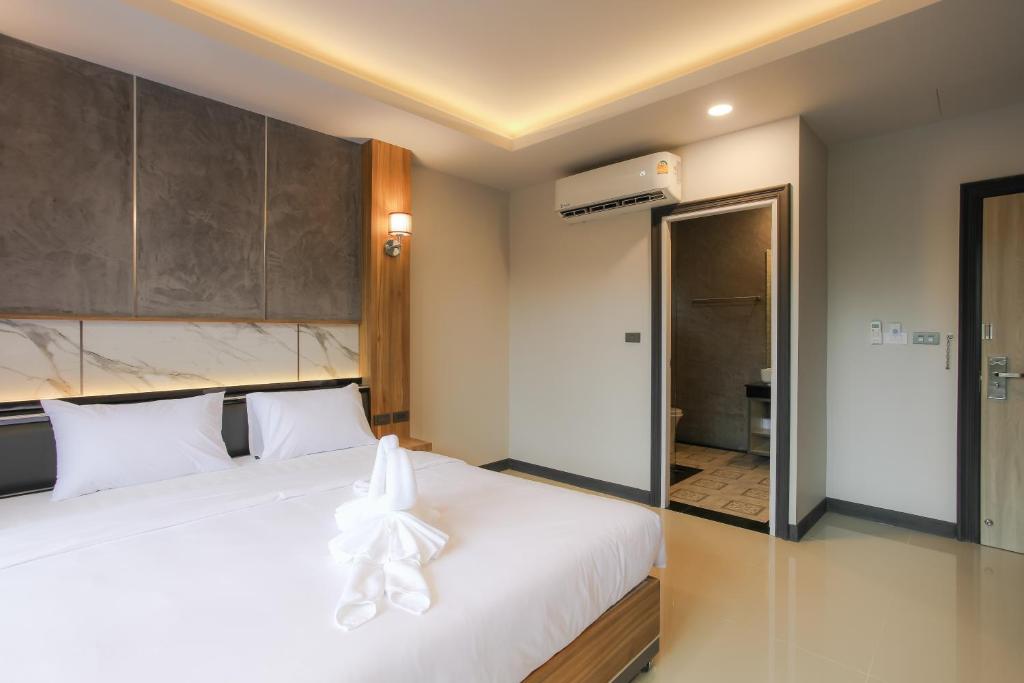 a bedroom with a white bed and a bathroom at The Mantra Hotel Kata Noi in Kata Beach