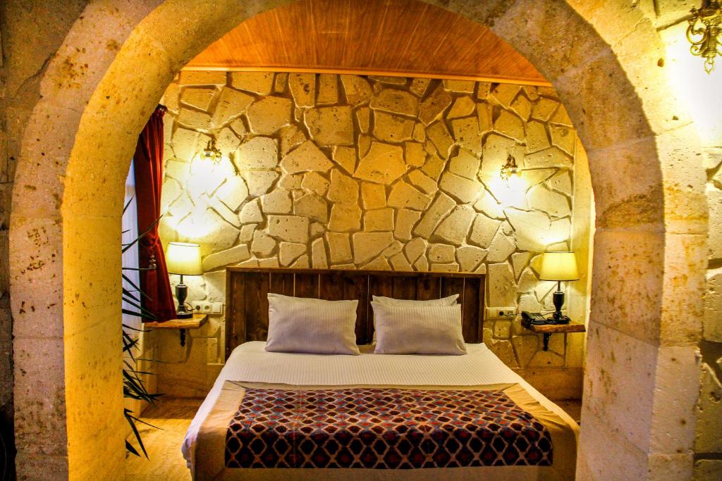 a bedroom with a bed in a stone wall at Corner in Cappadocia in Nevsehir