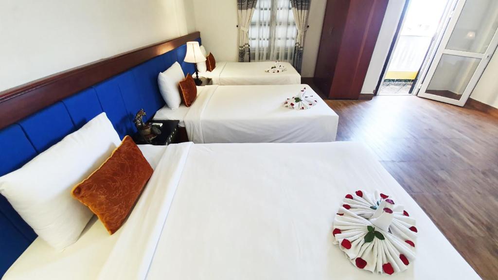 Postel nebo postele na pokoji v ubytování Hoi An Hai Au Boutique Hotel