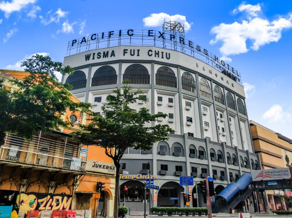 a white building with a sign on top of it at Pacific Express Hotel Chinatown in Kuala Lumpur