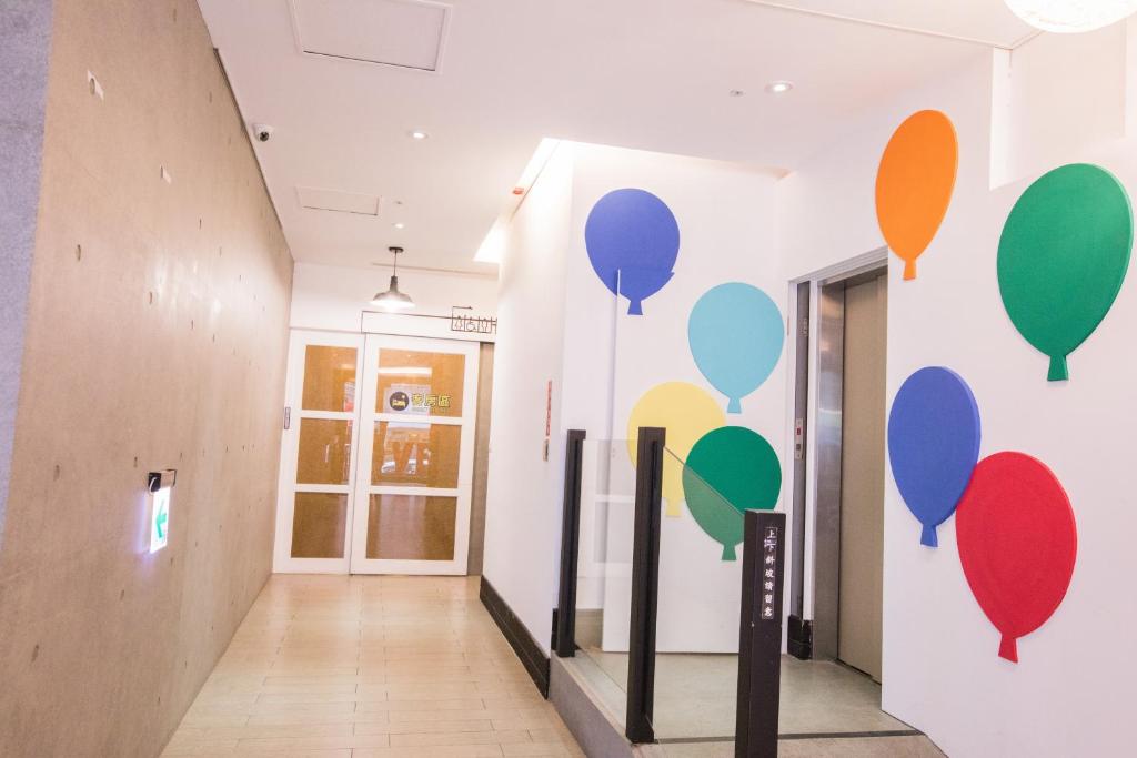 a hallway with a wall with balloons painted on it at Travel Art Inn in Chiayi City