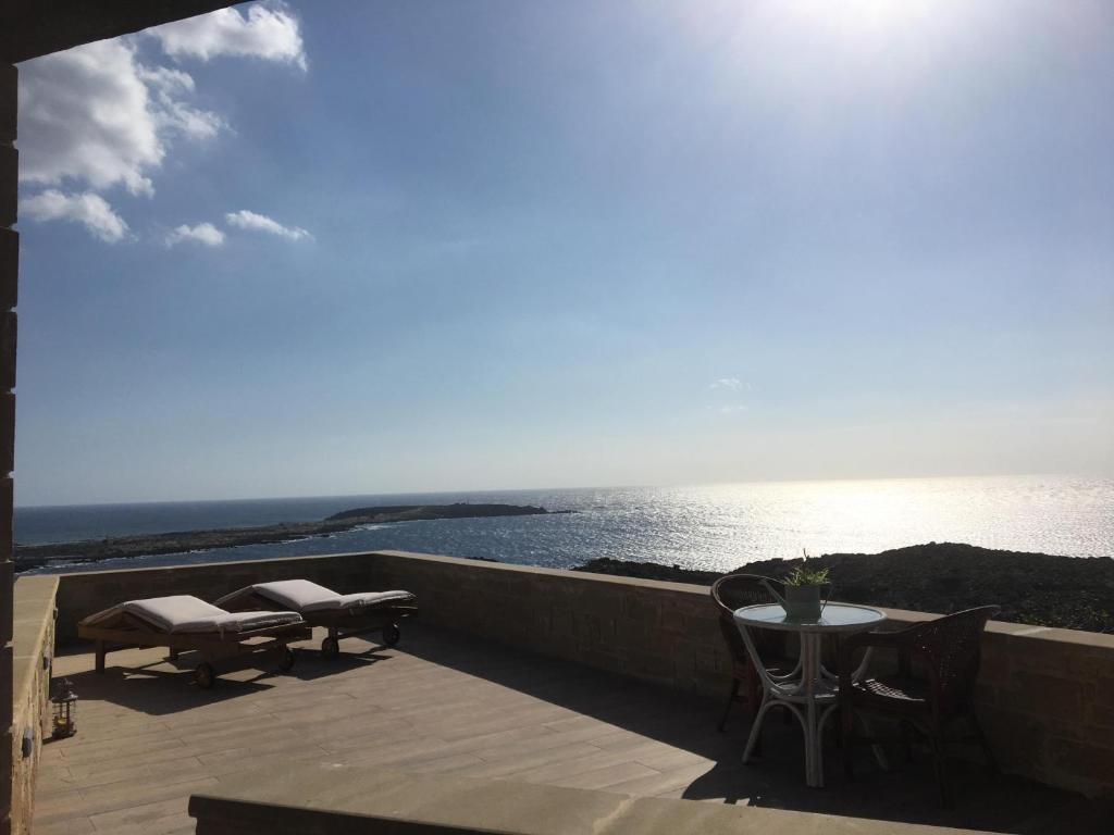 a balcony with a table and chairs and the ocean at Elafonisi Villa above the Beach in Elafonisi