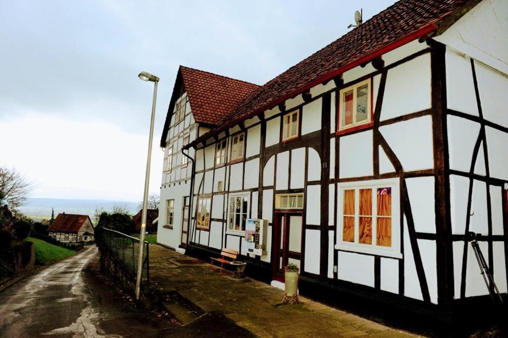 un bâtiment blanc et noir avec un toit rouge dans l'établissement John stube, à Rinteln