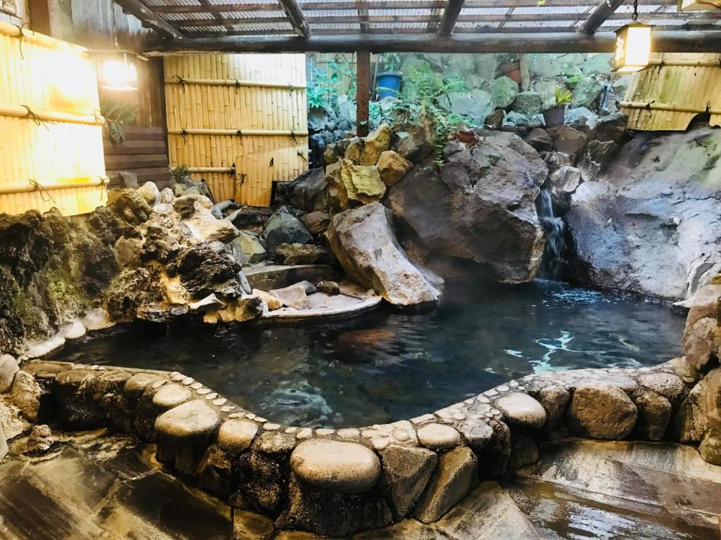 ein großer Pool mit Wasser in einem Zimmer mit Felsen in der Unterkunft Tsukinoya in Hakone