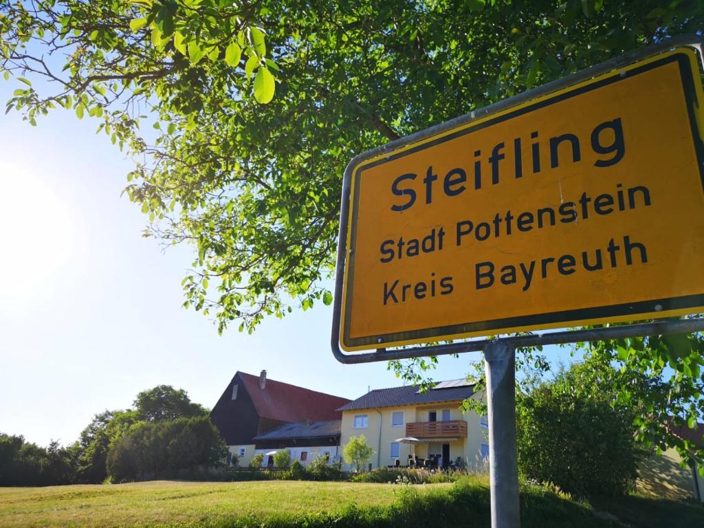 ein gelbes Straßenschild vor einem Haus in der Unterkunft Ferienwohnung Hutzler in Pottenstein