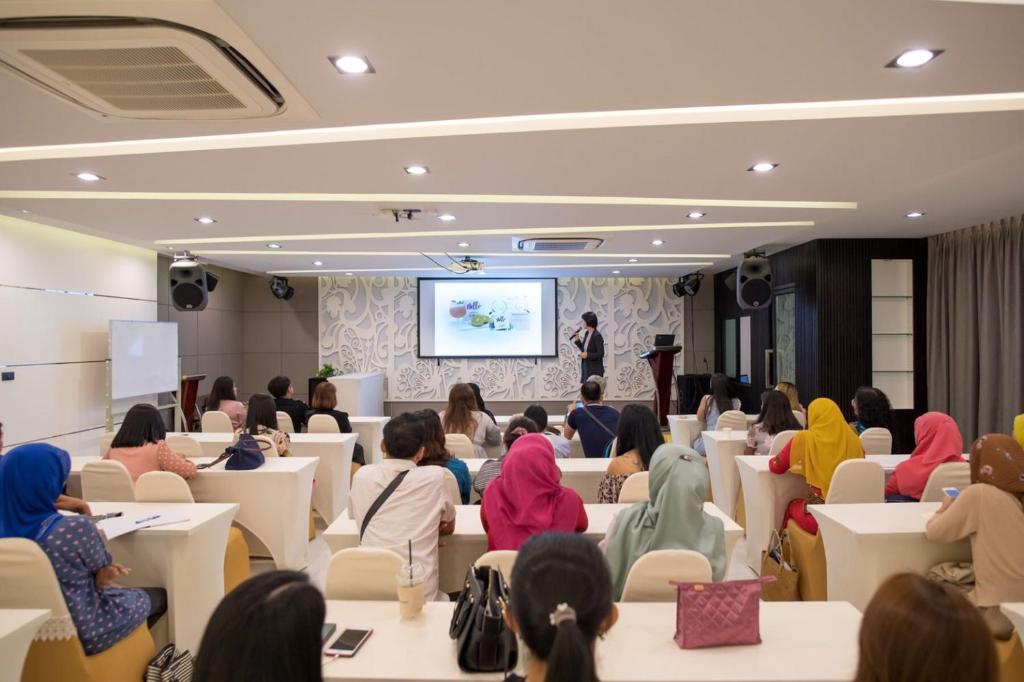 a group of people sitting in a room watching a presentation at River Front Krabi Hotel in Krabi