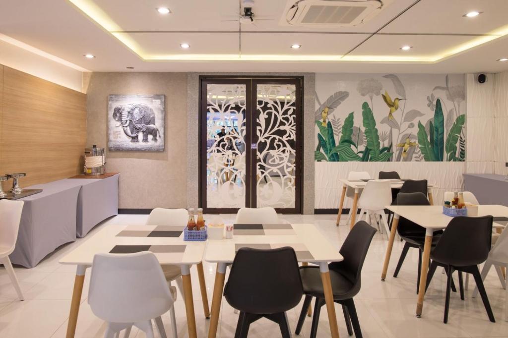 a dining room with white tables and chairs at River Front Krabi Hotel in Krabi