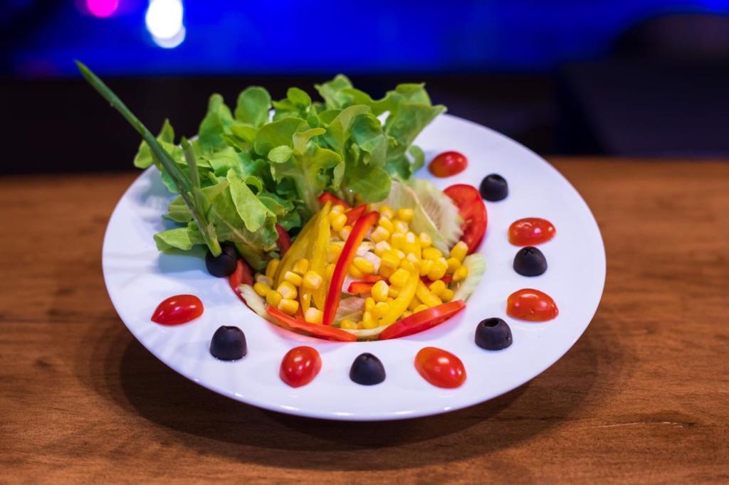 a plate with corn and vegetables on a table at River Front Krabi Hotel in Krabi