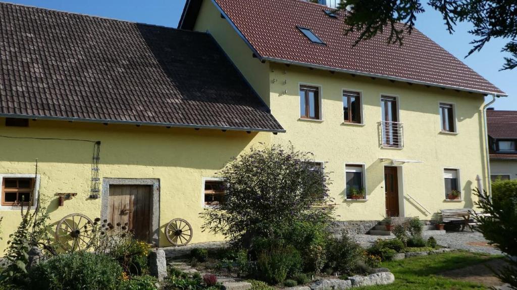 una casa amarilla con techo marrón en Ferienwohnung Schindler, en Nittenau