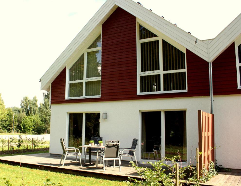 een huis met een tafel en stoelen op een terras bij Ferienhaus Nordhorn - Auf Wolke 7 und Seeparadies in Nordhorn