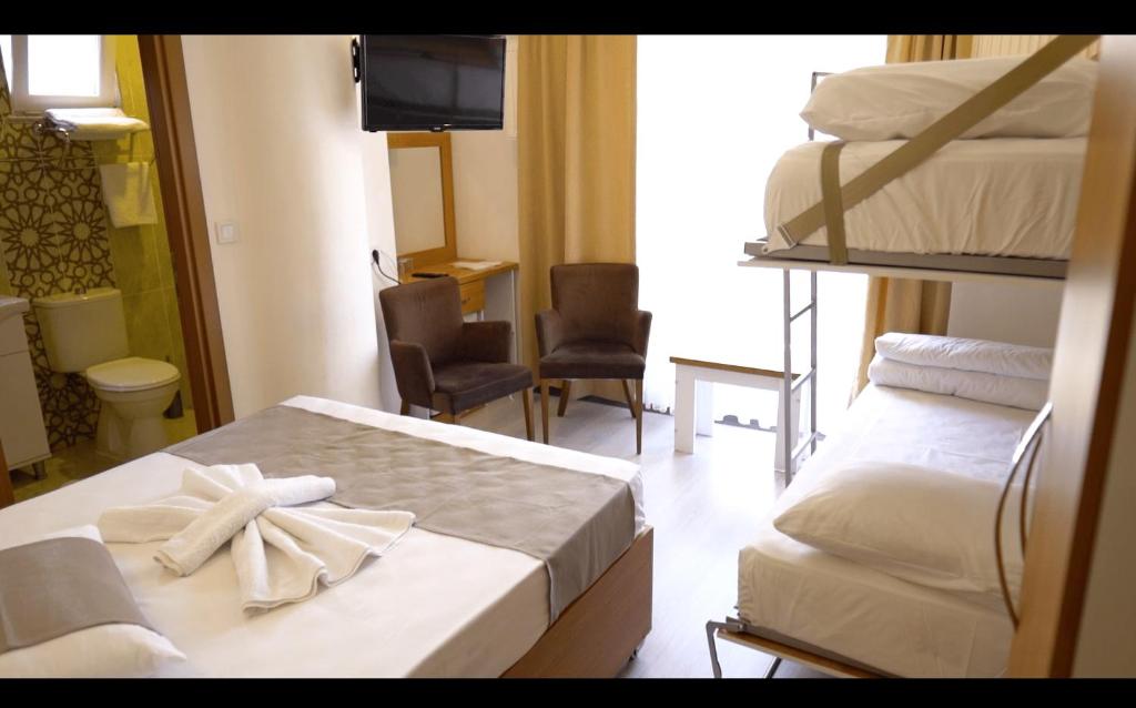 恰納卡萊的住宿－GÜVEN HOTEL，酒店客房设有两张双层床和电视。