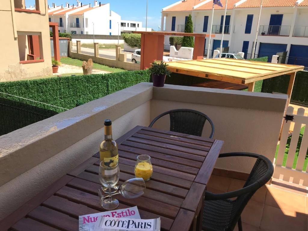 Una botella de vino sentada en una mesa de madera en un balcón en Mas Pinell Viu bé, en Torroella de Montgrí