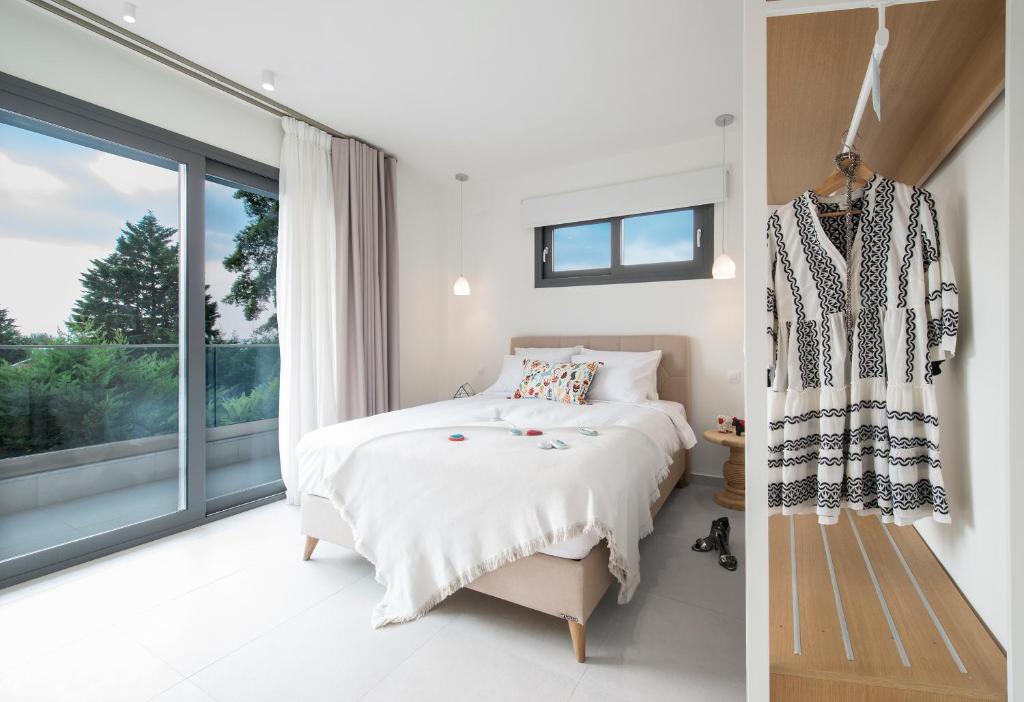 - une chambre avec un lit et une grande fenêtre dans l'établissement Mariya Art Living, à Nea Skioni