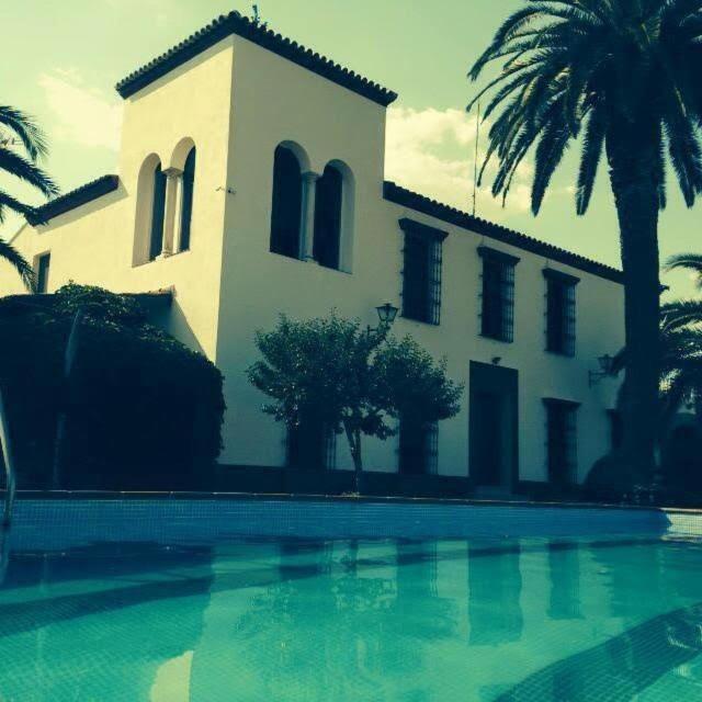 a house with a swimming pool in front of a building at FINCA LAS DEHESILLAS in Monesterio