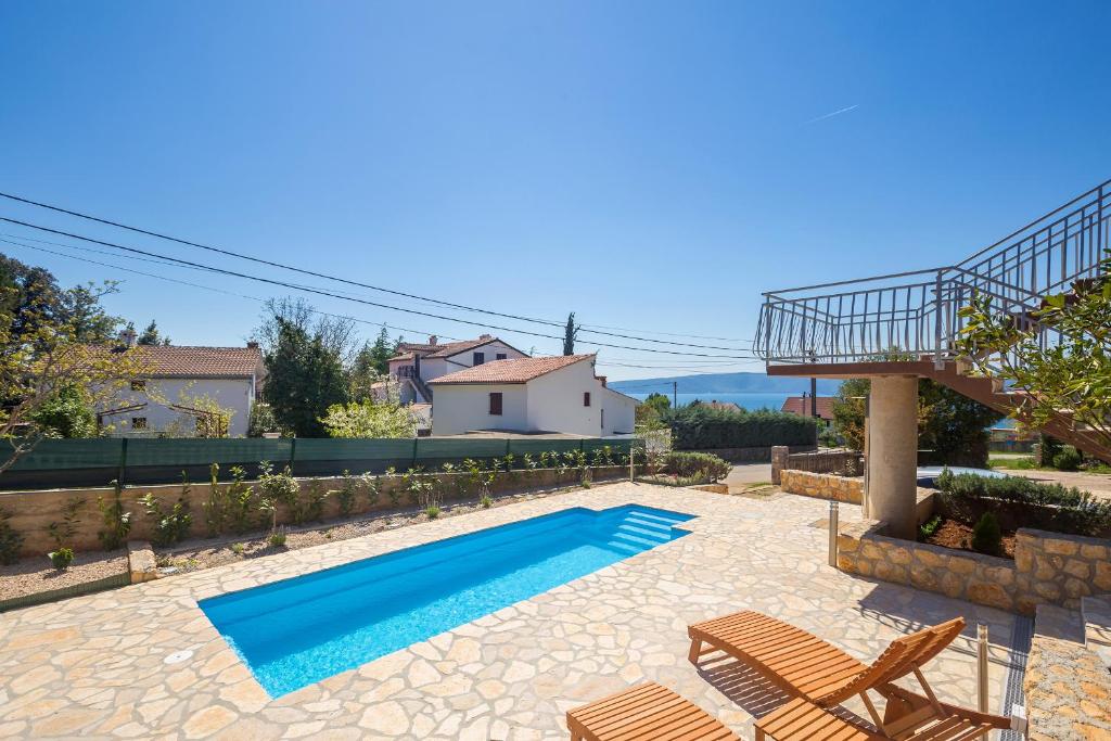 a swimming pool with two chairs and a house at Holiday Home Michael in Pinezici