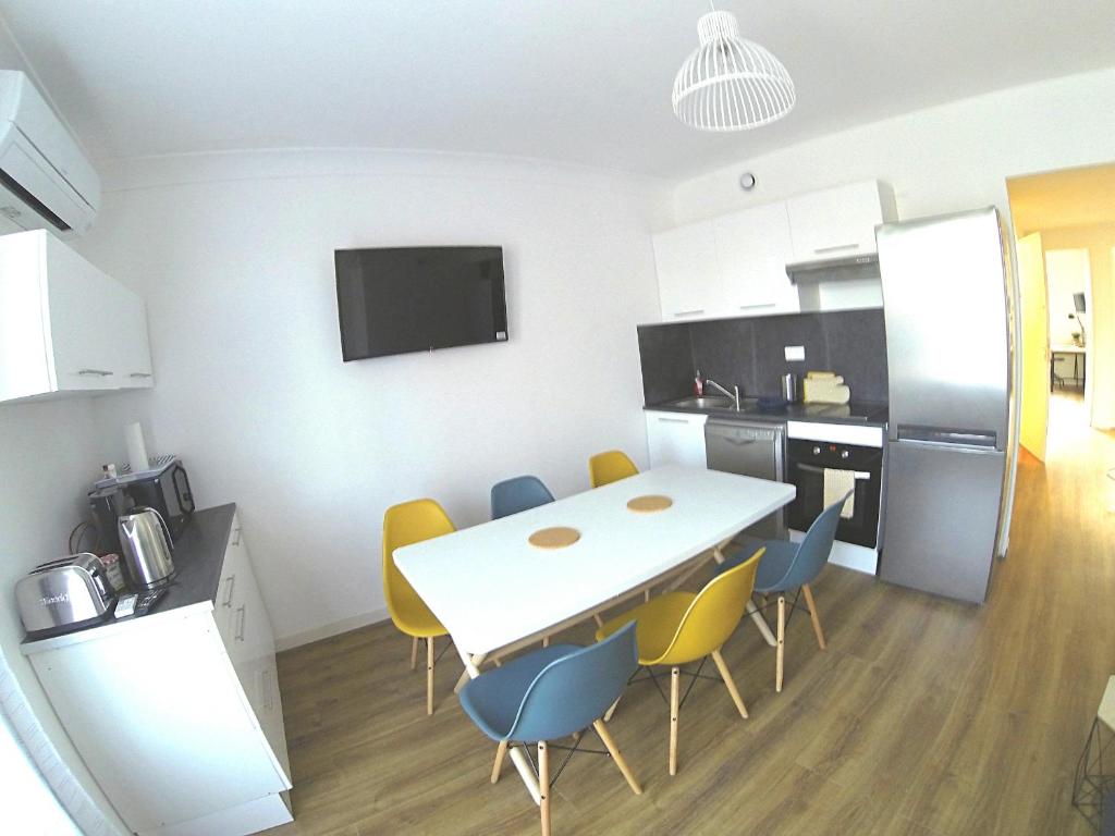 cocina y comedor con mesa y sillas en Superbe appartement, 3 chambres, gare St Charles, en Marsella