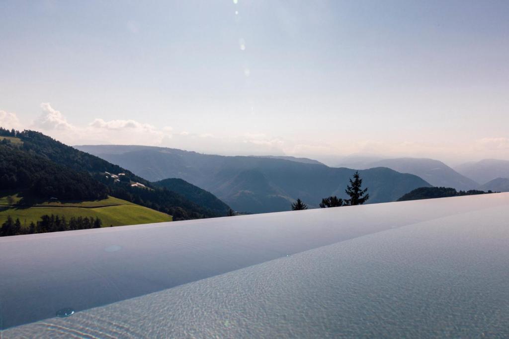 une grande étendue d'eau avec des montagnes en arrière-plan dans l'établissement Tschögglbergerhof, à San Genesio Atesino