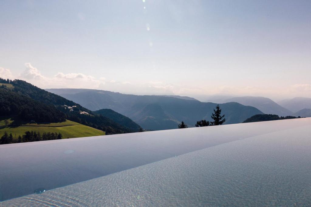 ein großer Wasserkörper mit Bergen im Hintergrund in der Unterkunft Tschögglbergerhof in Jenesien
