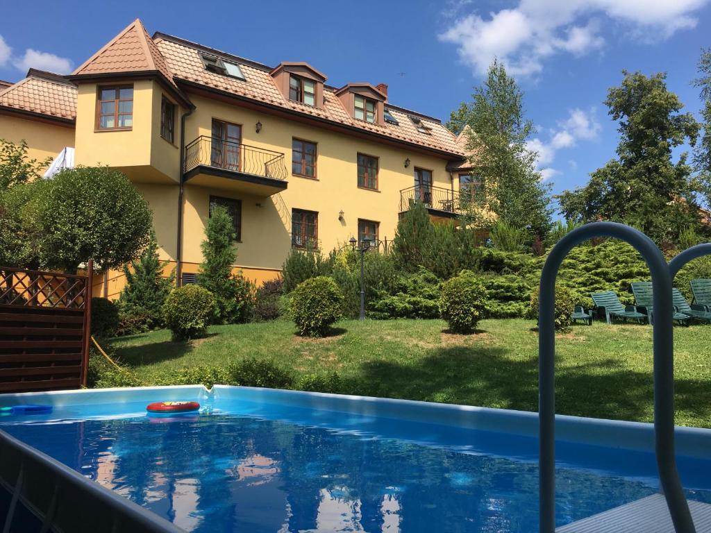 a swimming pool in front of a house at Villa Gorczańska in Rabka-Zdrój