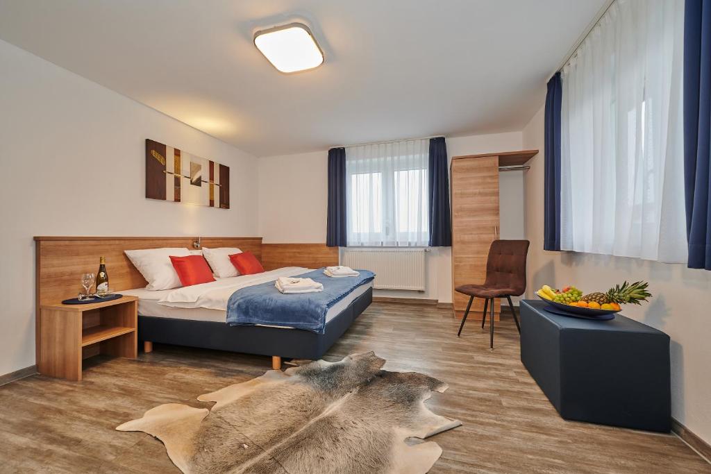 ein Hotelzimmer mit einem Bett und einem Tisch sowie einem Zimmer in der Unterkunft Sunny Hotel Straubing in Straubing