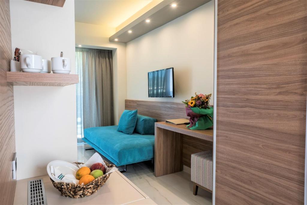 a living room with a blue couch and a table at Atrion Resort Hotel in Agia Marina Nea Kydonias