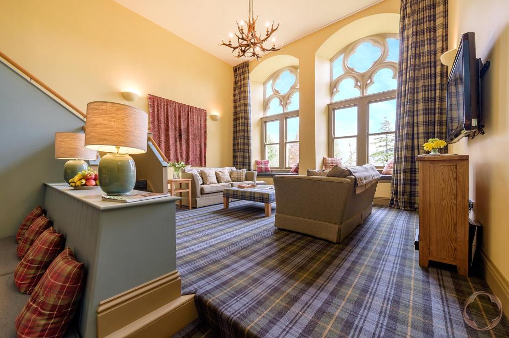 a living room with a couch and a living room with windows at Highland Club Direct in Fort Augustus