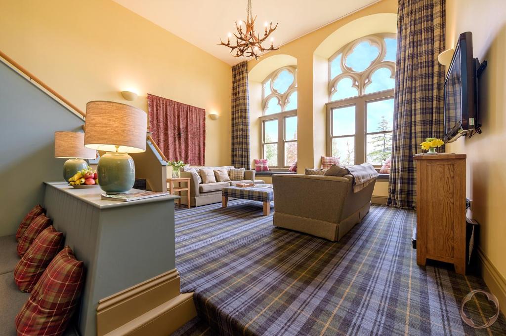- un salon avec un canapé et des fenêtres dans l'établissement Highland Club Direct, à Fort Augustus