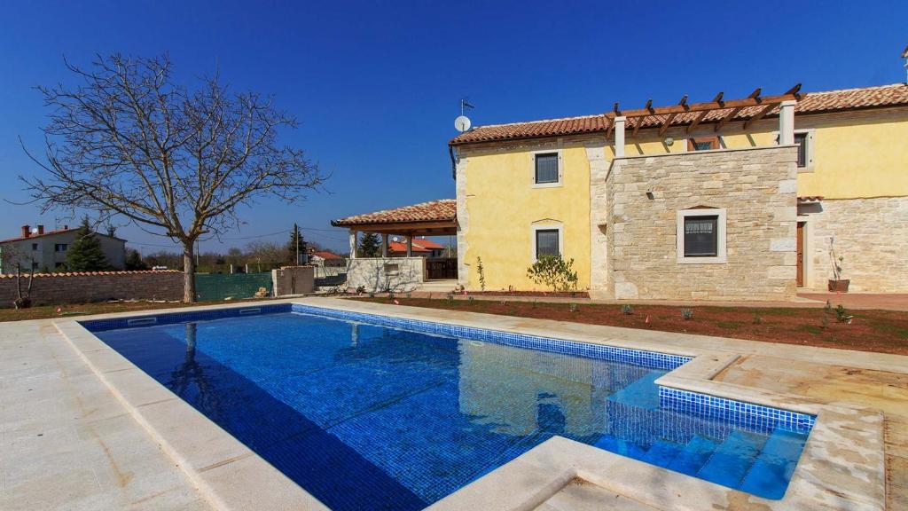 a swimming pool in front of a house at Istrian villa Orbanići with private pool for up to 12 persons in Orbanići