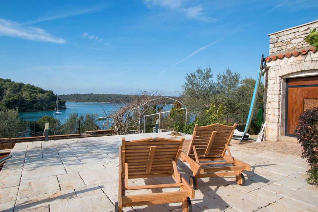2 sillas en un patio con vistas al agua en La Casa Ingrid - Couple's Paradise, en Pula