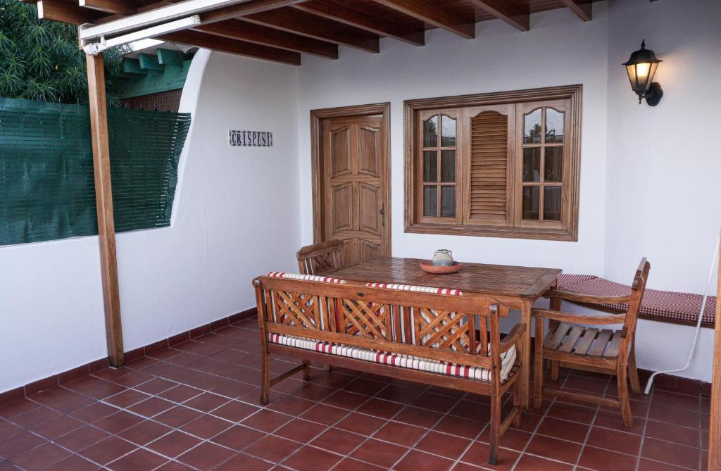 una mesa de madera y sillas en un patio en Playa Chica apartment, en Puerto del Carmen
