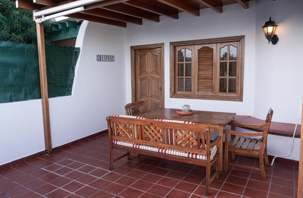 drewniany stół i krzesła na patio w obiekcie Playa Chica apartment w Puerto del Carmen