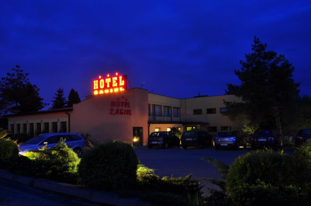 a building with a neon sign on top of it at Hotel Żagiel in Niewiesze