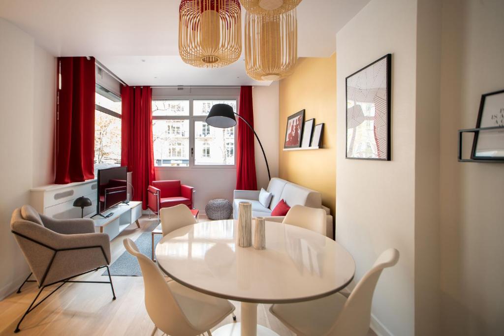 ein Wohnzimmer mit einem Tisch und Stühlen in der Unterkunft SUITE GIDE : au cœur de la Rive Gauche, neuf, design, 2/4 personnes in Paris