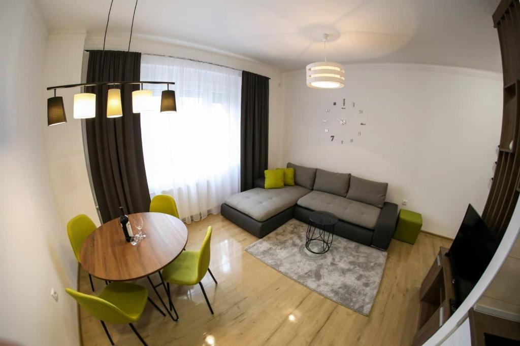 ein Wohnzimmer mit einem Sofa und einem Tisch in der Unterkunft Ancora apartment Lana in Novi Sad