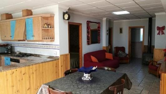 Casa Rural Villa Micleta في كايوسا ديه إنساريا: مطبخ وغرفة معيشة مع طاولة وأريكة