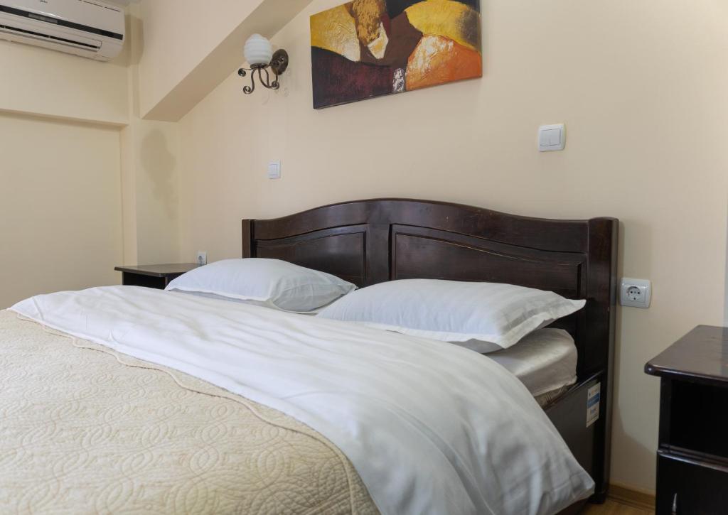 a bedroom with a large bed with white sheets and pillows at Pensiunea Splendid in Dorohoi