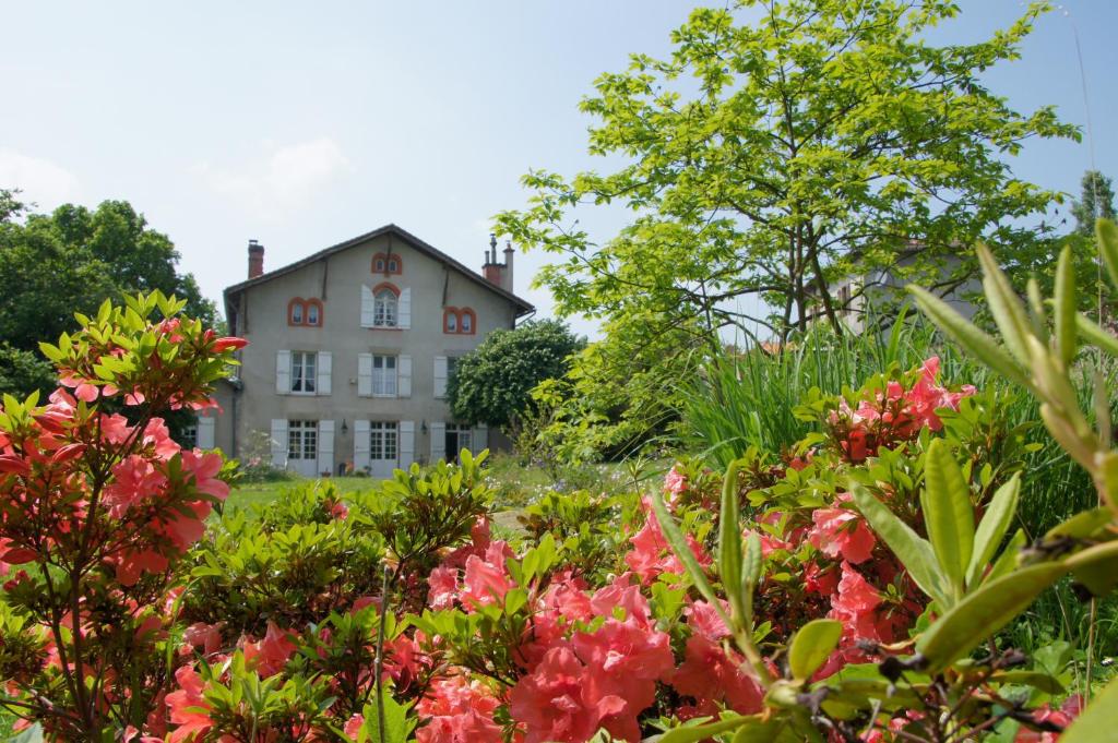 une maison au milieu d'un jardin fleuri dans l'établissement Le Clos de La Muse, à Saint-Junien