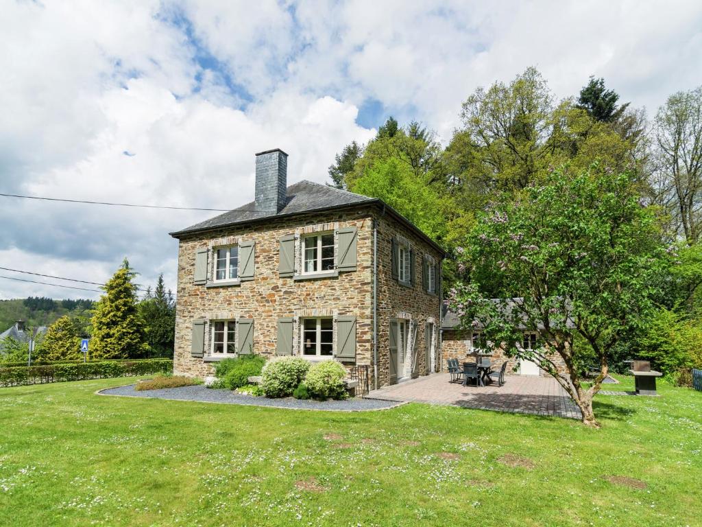 een groot stenen huis met een grasveld bij Spacious Cottage with Private Garden in Ardennes in Frahan